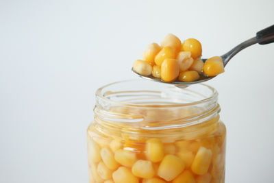 Close-up of pills in jar against white background