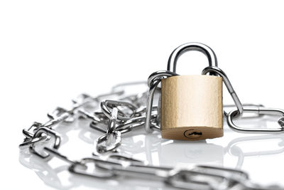 Close-up of padlock and chain on white background