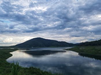 Scenic view of lake by mountains against sky