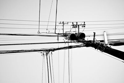 Low angle view of electricity pylon against clear sky