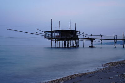 Pier over sea against sky at dusk