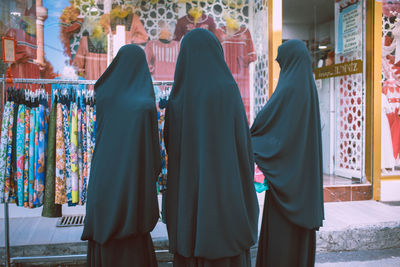 Rear view of women standing at store