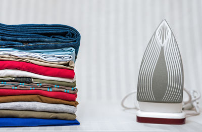 Stack of textiles with iron on table