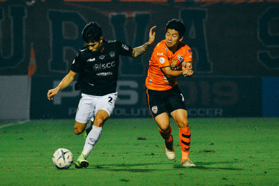 Low angle view of people playing soccer ball