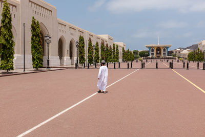 Rear view of woman walking against building