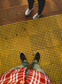 Low section of man standing on tiled floor