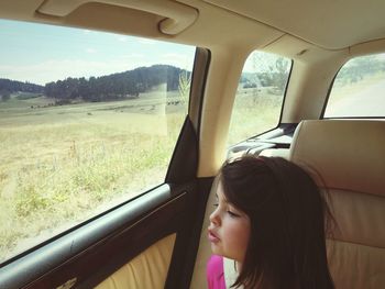 Side view of a woman in car on landscape