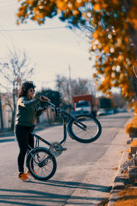 Woman playing with her bicycle in the street