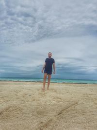 Full length of man standing on beach against sky