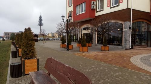 Street by buildings in city against sky