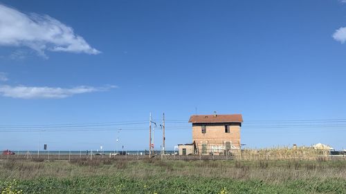 Built structure on field against blue sky