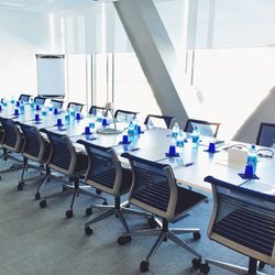 Empty chairs by bottles on conference table