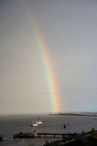 Scenic view of rainbow over sea against sky