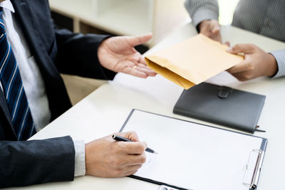 Midsection of man working on table