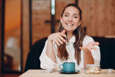 Portrait of young woman drinking coffee in cafe