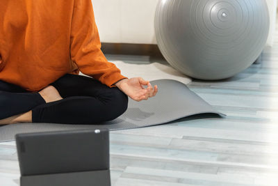 Low section of woman doing yoga at home