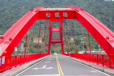 Red bridge leading towards mountain