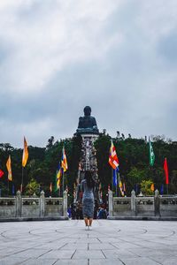 Rear view of people at temple against sky