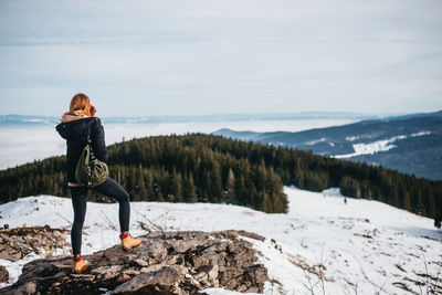 Woman standing on snow covered mountain