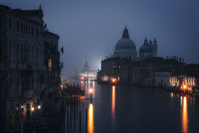 Illuminated buildings in city at night with grand canal