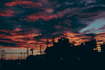 Low angle view of silhouette buildings against dramatic sky