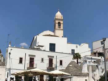 Low angle view of whitewashed buildings in town against blue sky