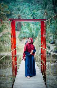 Full length of woman standing on footbridge