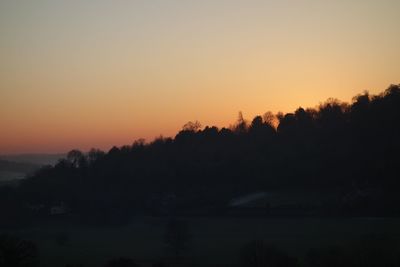 Silhouette trees against sky during sunset