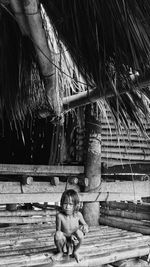 Rear view of two women sitting on wood