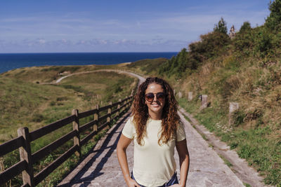 Portrait of smiling young woman on sea shore