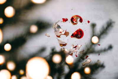 Broken christmas ornament on the floor by tree