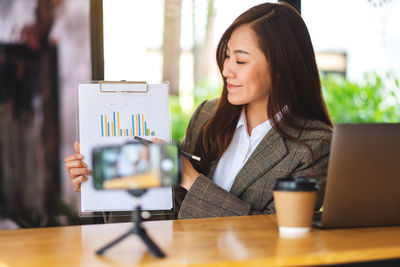 Businesswoman with graph working at desk in office
