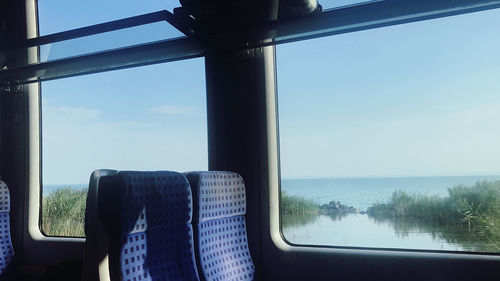 Train against sky seen through window