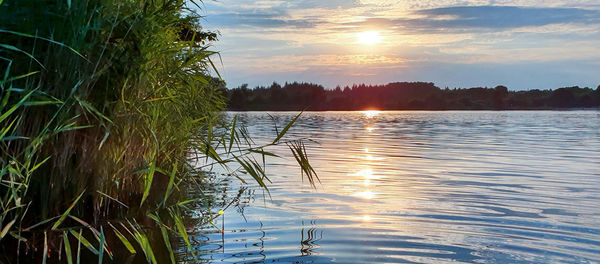 Scenic view of lake against sky during sunset