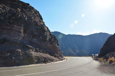 Road by mountain against sky