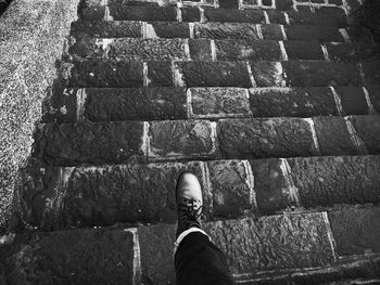 Low section of man standing on stone wall