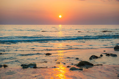 Scenic view of sea against orange sky