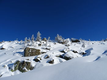 Snow covered mountain against blue sky