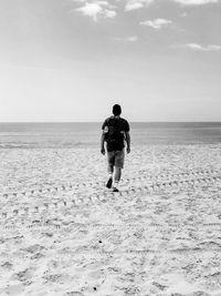 Rear view of man standing on beach