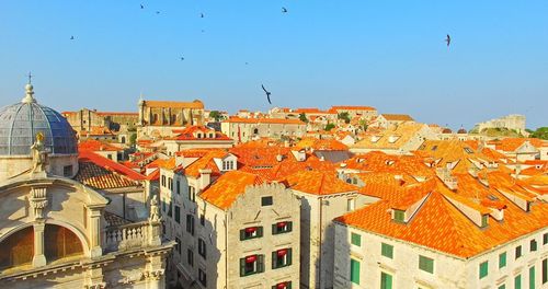 View of buildings in city against clear blue sky