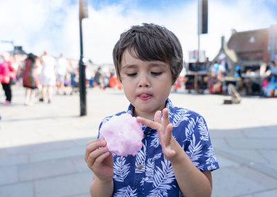 Boy holding ice cream in city