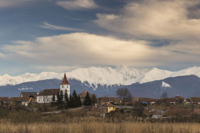 Houses on snowcapped mountain against sky