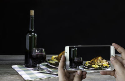 Man photographing wine in glass