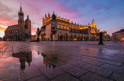 View of historical building at sunrise in the main square of krakow after the rain, poland