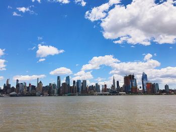 Sea by cityscape against sky