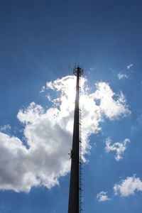 Low angle view of silhouette windmill against blue sky