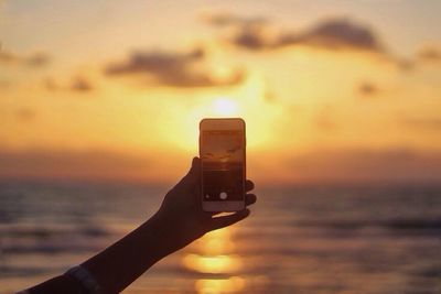 Close-up of cropped hand holding camera