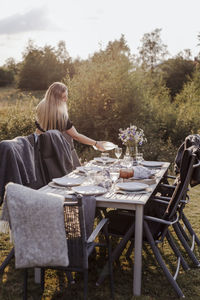 Rear view of woman sitting on table