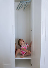 Little girl crying out loud in an empty wardrobe