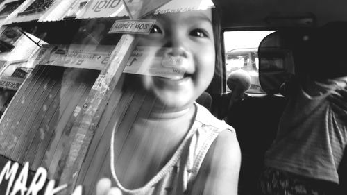 Close-up portrait of smiling young woman in car